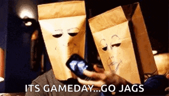 a couple of people with paper bags on their heads talking on a cell phone .