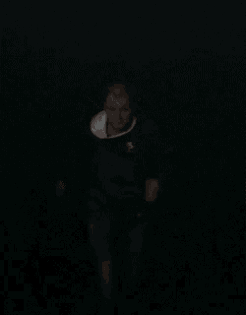 a blurry picture of a man wearing a black shirt with the letter s on it