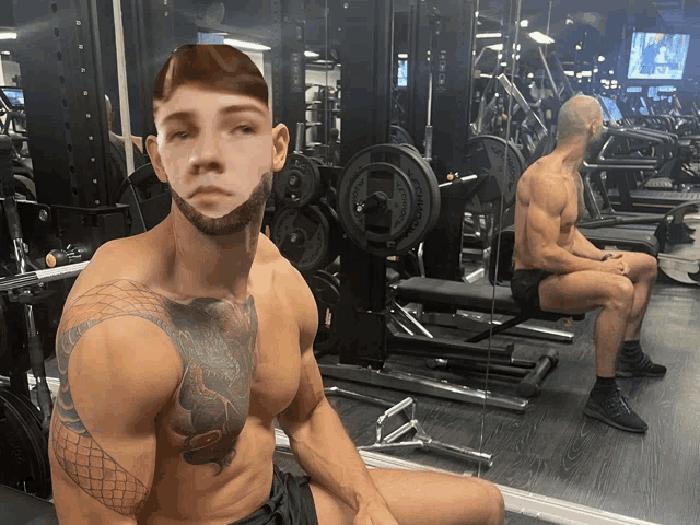 a man with a tattoo on his chest sits in front of a gym machine that says ' rogue ' on it