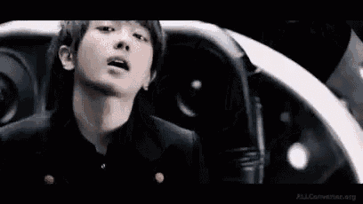 a young man in a black suit is sitting in a car .