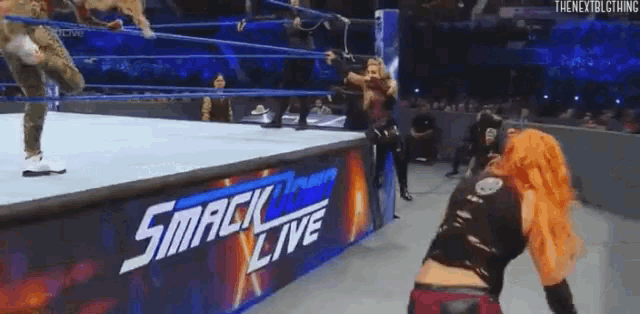 a woman is wrestling in a ring with a sign that says smack live