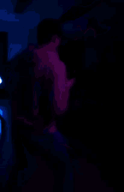 a blurry picture of two people dancing in a dark room with blue lights behind them