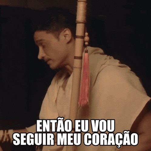 a man holding a bamboo stick with the words então eu vou seguir meu coracao written below him