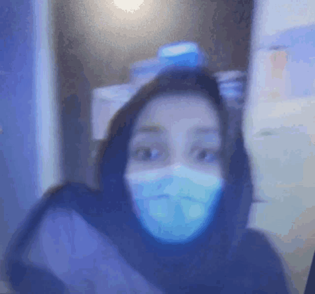 a woman wearing a mask is looking at the camera
