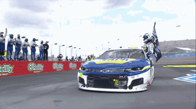 a race car is on a track with o'reilly in the background
