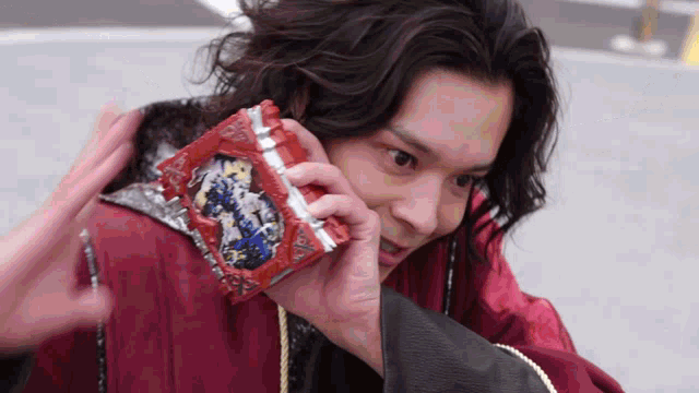 a man in a red jacket is holding a red item