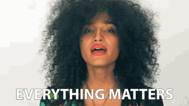 a woman with curly hair says everything matters in front of a white background
