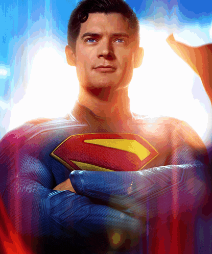 a man in a superman costume with his arms crossed looks at the camera