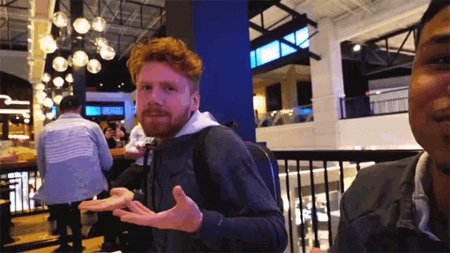 a man with red hair and a beard wearing a nike jacket