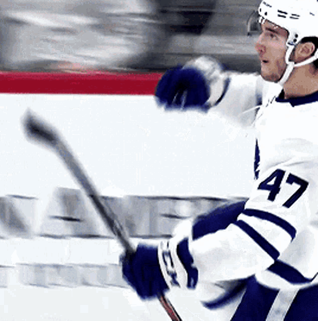 a hockey player with the number 47 on his jersey is holding a hockey stick