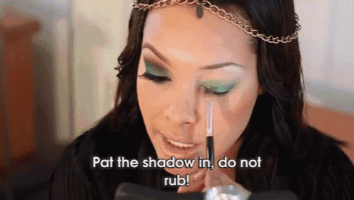 a woman is applying green eye shadow with the words pat the shadow in do not rub .