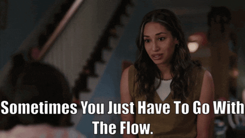 a woman is sitting in front of a sign that says " sometimes you just have to go with the flow . "