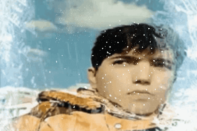 a man 's face is visible through a snowy window