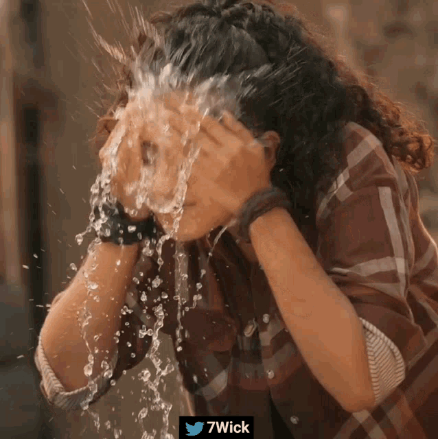 a woman is splashing water on her face with a 7wick watermark
