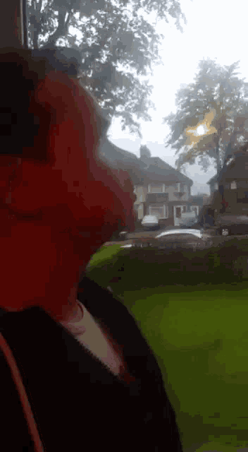 a person with red paint on their face looks out a window