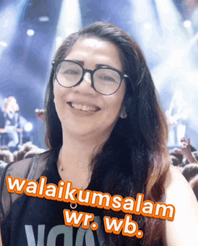 a woman wearing glasses and a shirt that says wb smiles for the camera