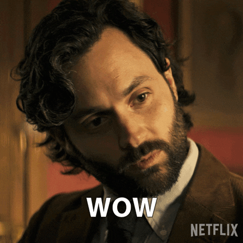 a man with a beard and a suit has the word wow on his face