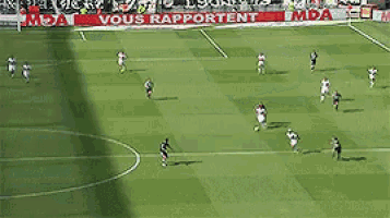 a group of soccer players are playing on a field with a vous rapportent sign in the background