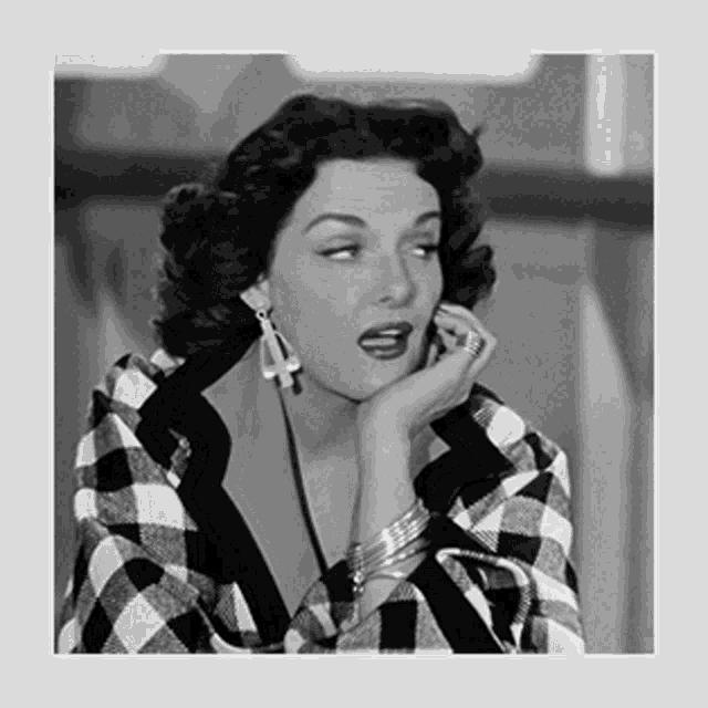 a black and white photo of a woman wearing earrings