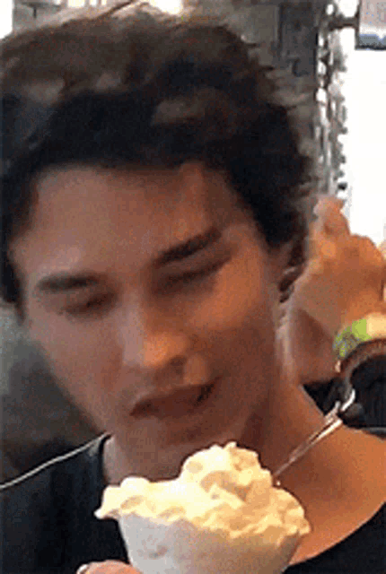 a man is eating ice cream with a fork in his mouth