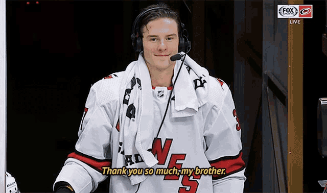 a hockey player wearing headphones and a towel around his neck says " thank you so much my brother "