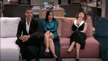 a man and two women are sitting on a couch that has the word poltron on it