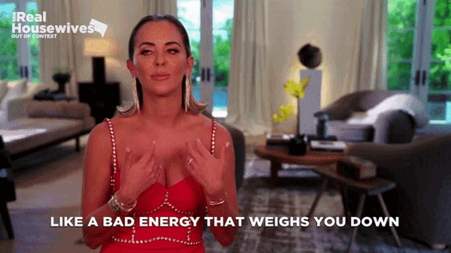 a woman in a red dress is talking about a bad energy that weighs you down