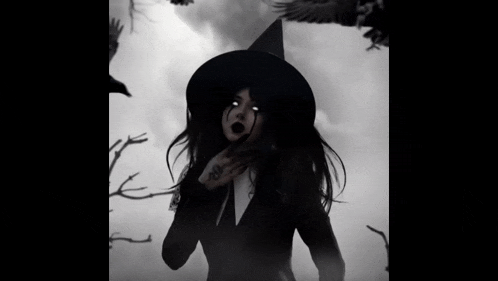 a woman dressed as a witch with a tattoo on her hand