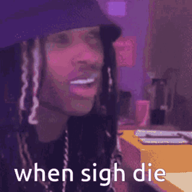 a man wearing a hat and dreadlocks is pointing at the camera with the words `` when sigh die '' .