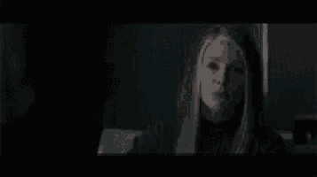 a close up of a woman 's face in a dark room .