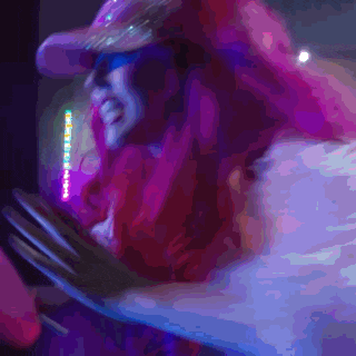 a blurry picture of a person 's face with a pink hat and sunglasses