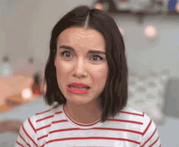 a woman wearing a red and white striped shirt makes a funny face