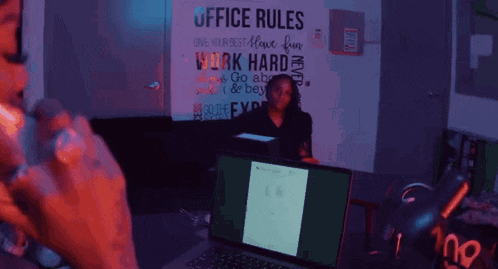 a woman is talking on a cell phone while sitting in front of a computer .