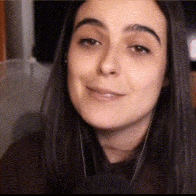 a close up of a woman 's face with headphones around her neck .