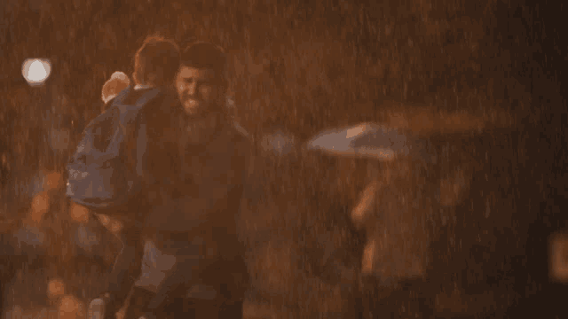 a man carrying a child in the rain with an umbrella