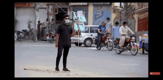a man wearing a mask stands in the middle of a street in front of a pepsi sign