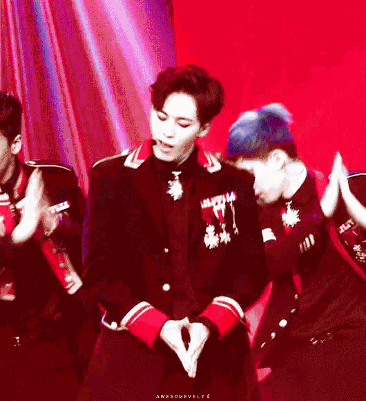 a man in a suit and tie is dancing on a stage with other people .