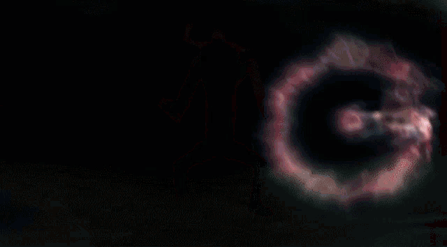 a blurred image of a person in a dark room with a red circle in the middle
