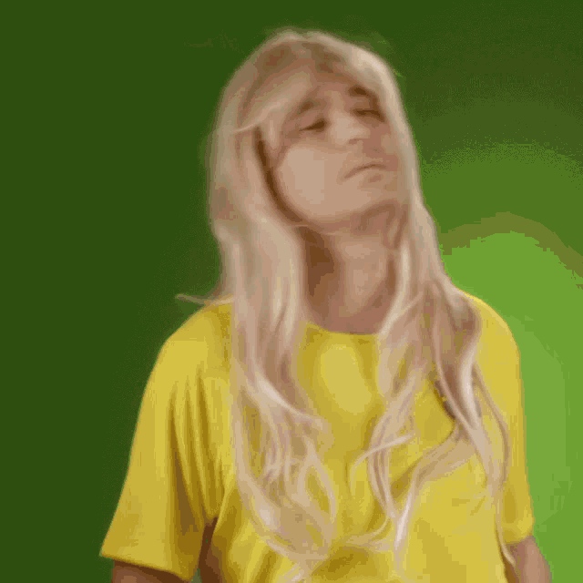 a woman with blonde hair is wearing a yellow top