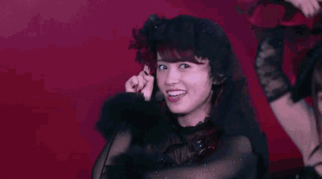 a woman in a black dress is dancing on a stage with a microphone .