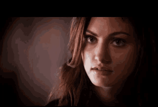 a close up of a woman 's face with a black background
