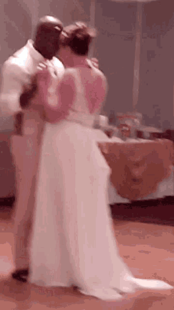 a bride and groom are dancing together at their wedding reception .
