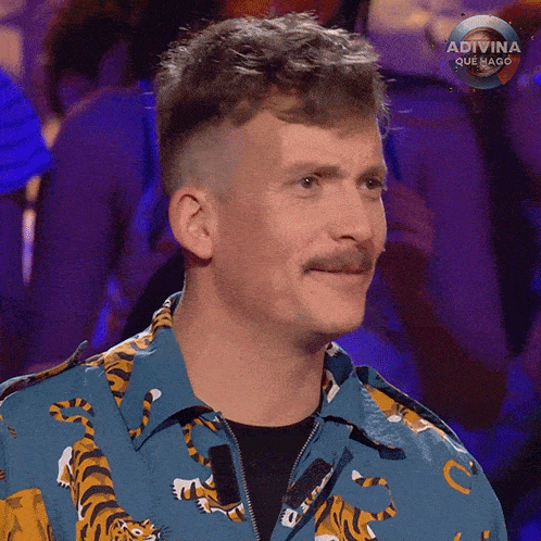 a man with a mustache is wearing a blue shirt with a tiger print