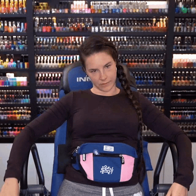 a woman is sitting in a chair with a fanny pack on her waist that says ina