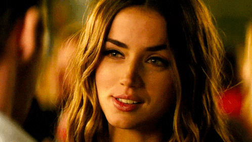 a close up of a woman 's face with a man behind her