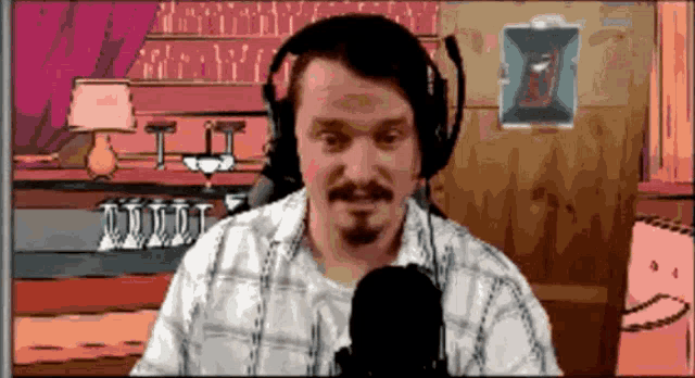 a man wearing headphones is talking into a microphone in front of a bar
