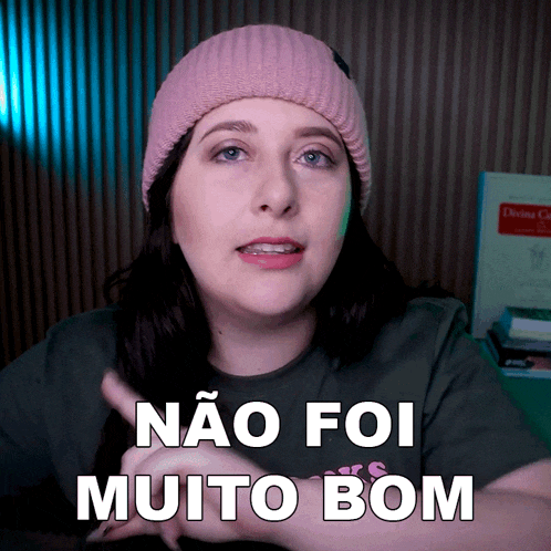 a woman wearing a pink beanie and a green shirt says não foi muito bom