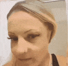 a close up of a woman 's face with a nose ring on her nose .