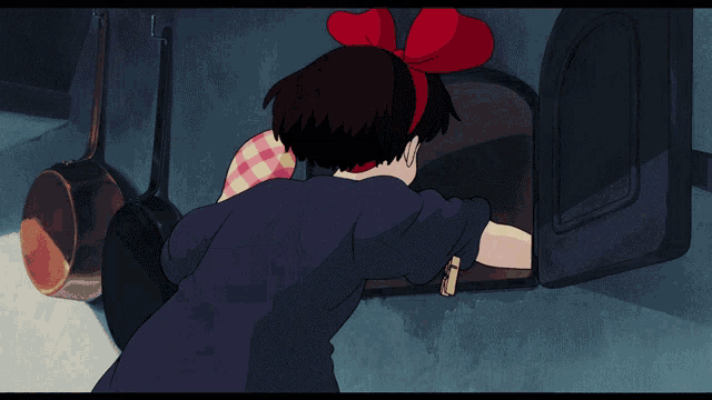 a girl with a red bow on her head is wearing a pink plaid oven mitt