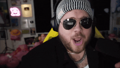 a man wearing sunglasses and a beanie with the letter a on it